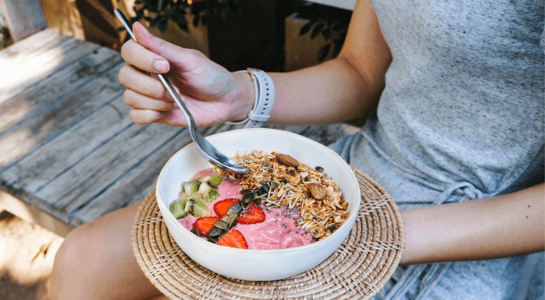 fata care mananca un smoothie bowl raw vegan