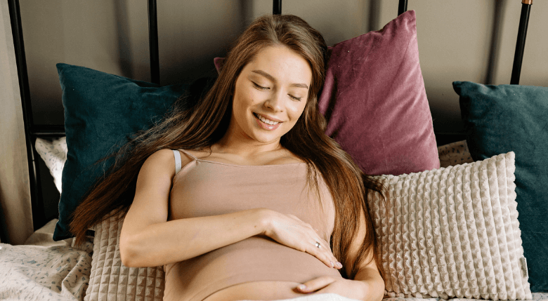 femeie gravidă întinsă în pat