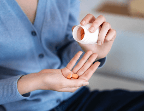 Care sunt cele mai bune suplimente pentru colesterol (femeie care ia pastile, suplimente pentur colesterol, pulover albastru)